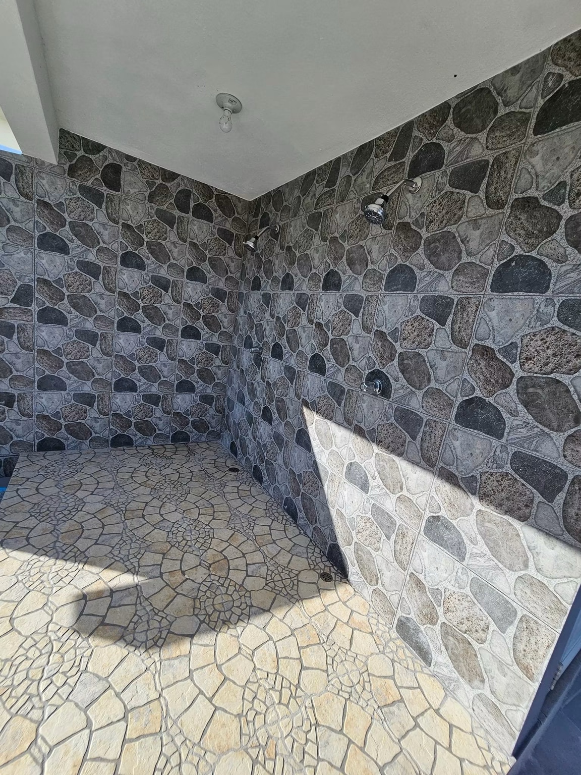 Ducha exterior doble junto al área de piscina