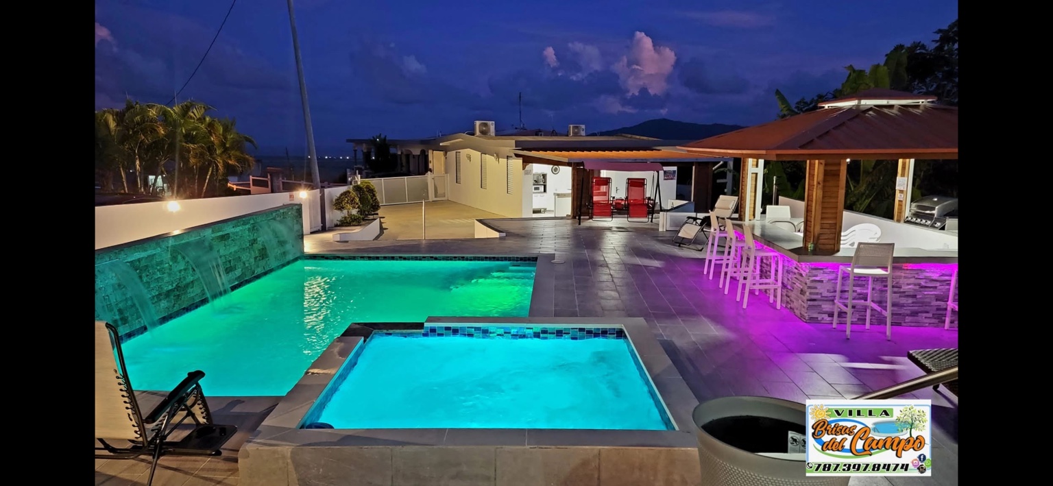 Piscina, jacuzzi y gazebo iluminados de noche